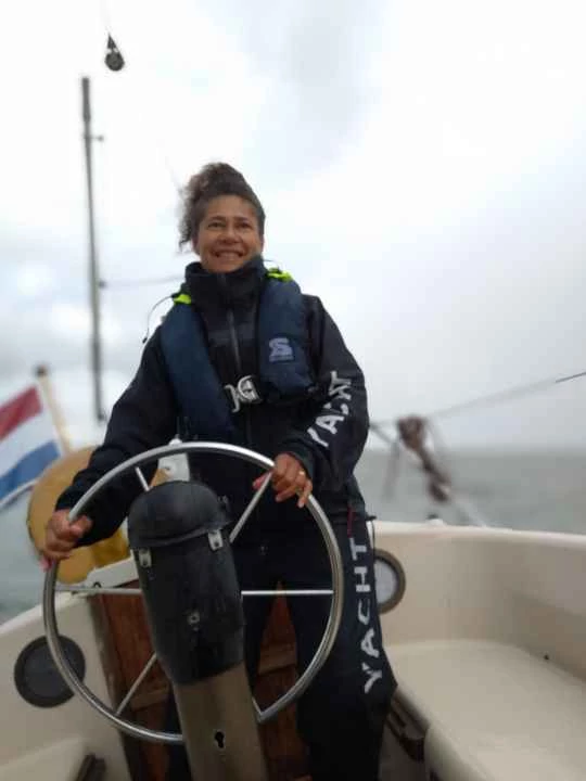 Kinder- en gezinscoach Fiona staat aan het roer van haar zeilboot. De wind waait stevig en het kompas helpt haar om in de mist de juiste koers te bepalen. Op de foto is Fiona net uit de mist gevaren.